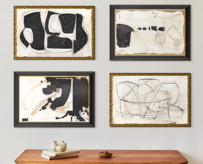 Room interior with brown table against a wall with 6 black and white abstract paintings.